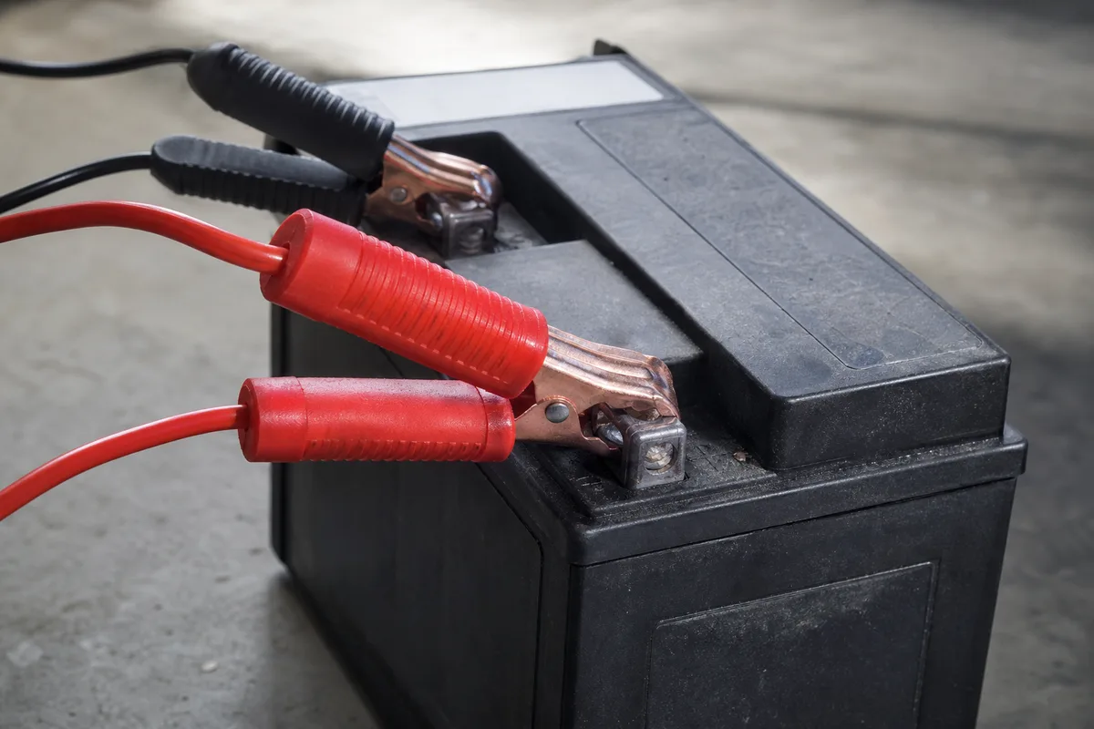 Écran de contrôle d’un chargeur intelligent relié aux bornes d’une batterie de moto